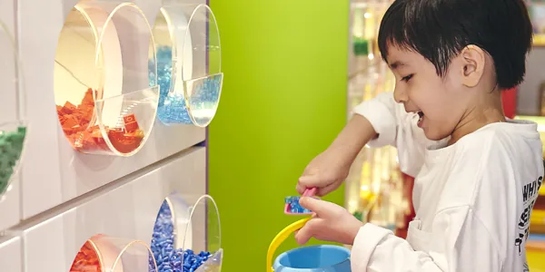 ショップ内・レゴブロック量り売り「Pick A Brick」でレゴパーツをすくっている男の子